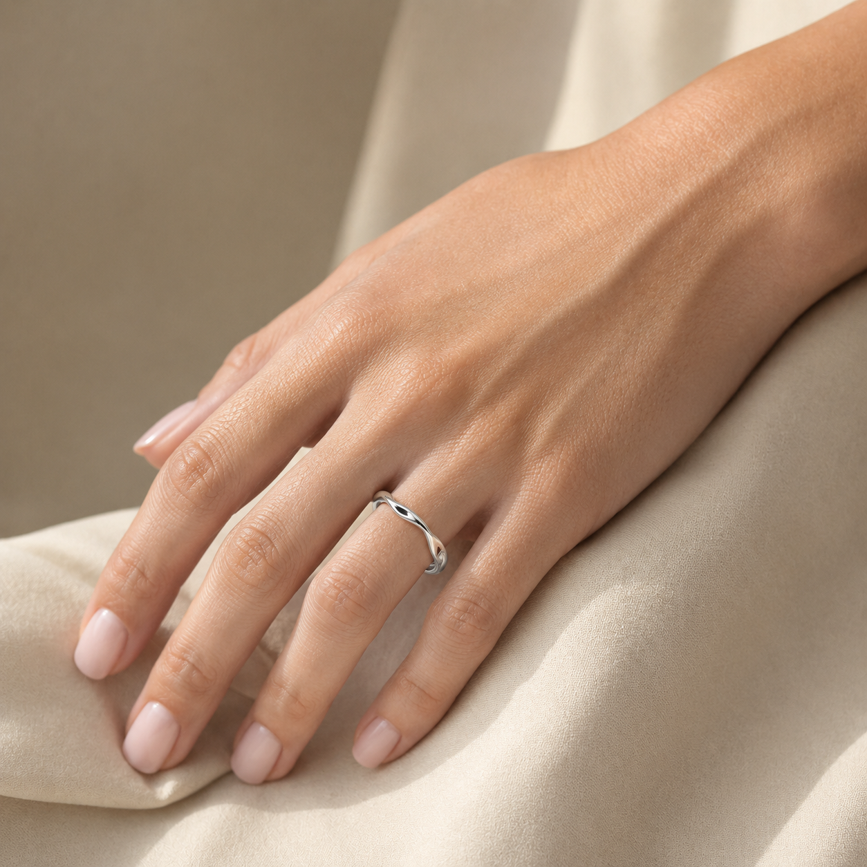 Sterling silver twisted ring worn on a woman's finger, showing the slim adjustable open ban